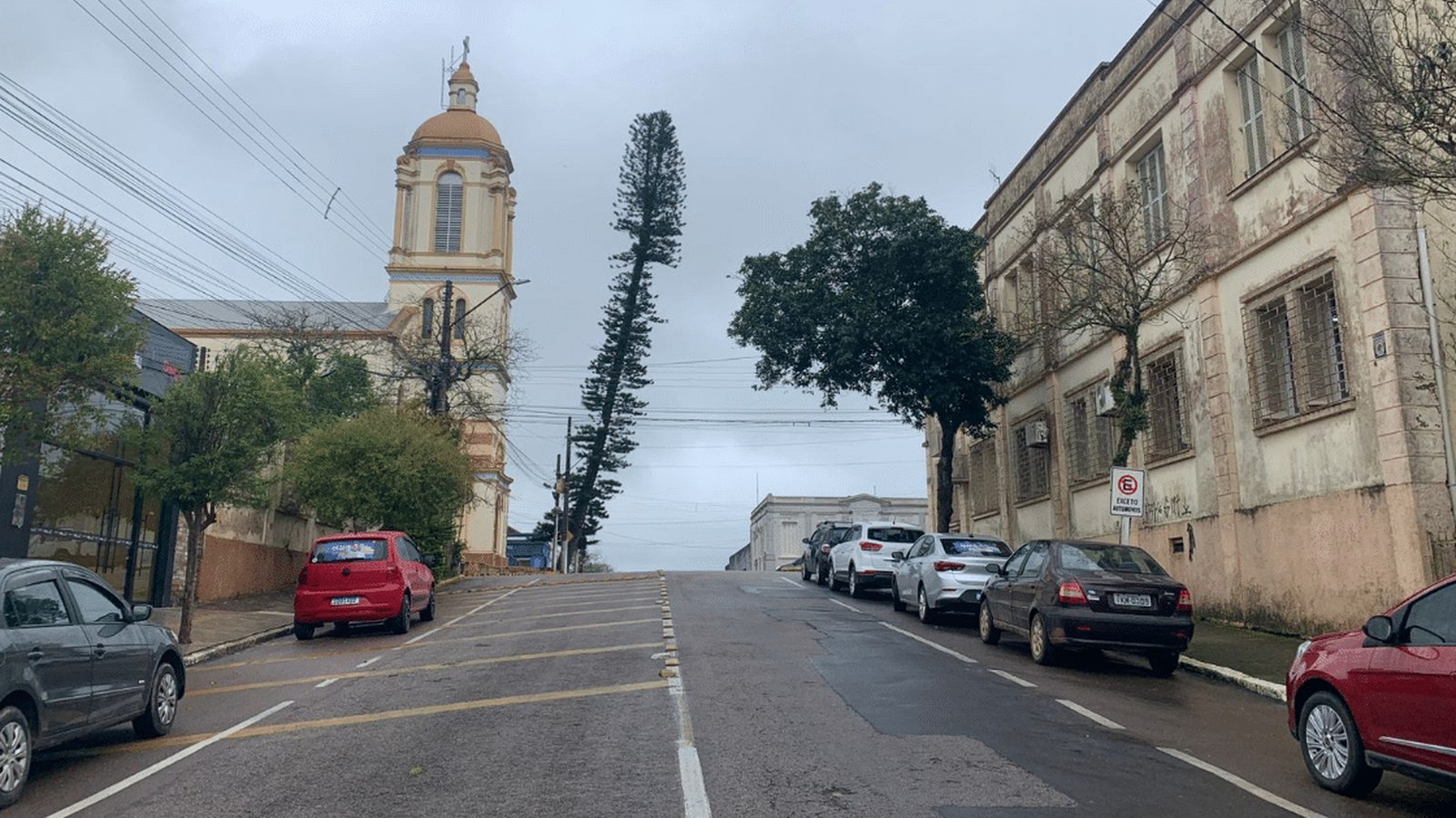 Rua da Costa Doce em dia de vento e chuva fraca, com moradores agasalhados contra o frio que se aproxima