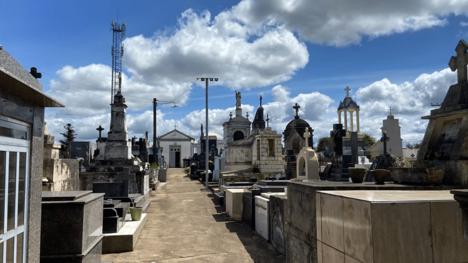 Portão de cemitério com flores depositadas em visita de Dia de Finados