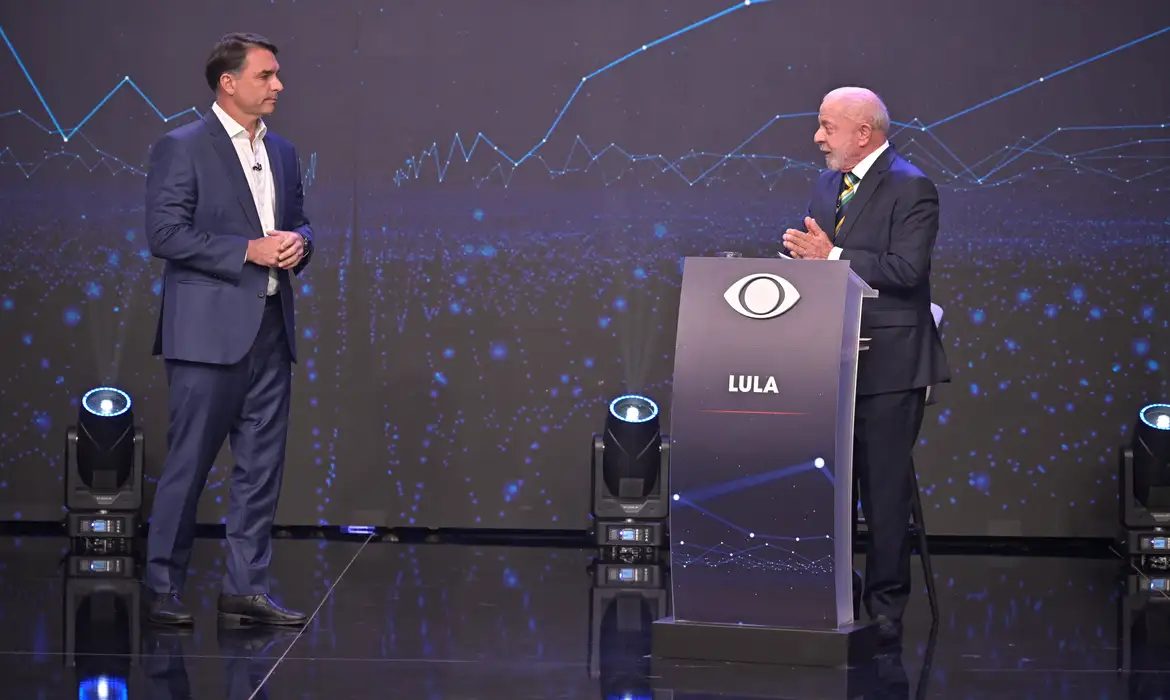 Lula e Flávio Bolsonaro durante debate presidencial realizado neste domingo (18)