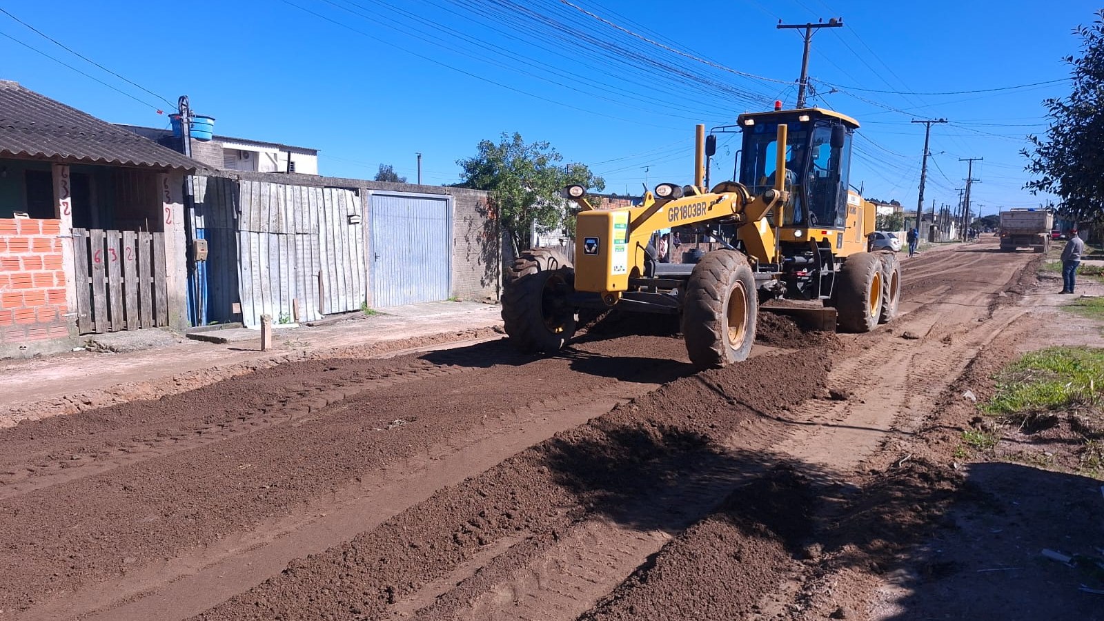 Motoniveladora realiza patrolamento em rua de terra de bairro de Pelotas após período de chuvas