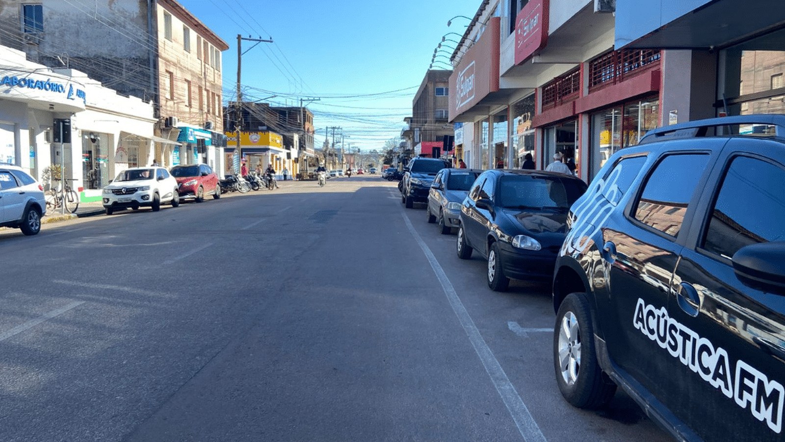 Pessoa agasalhada enfrenta vento forte em rua de Camaquã durante o feriado